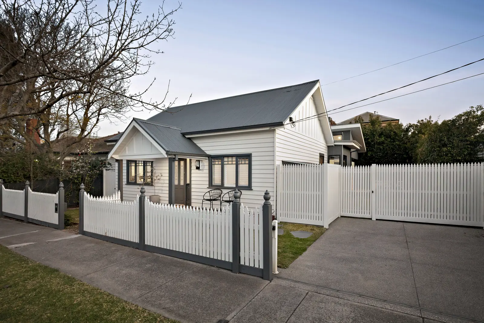 Restored weatherboard Californian bungalow behind a white picket fence